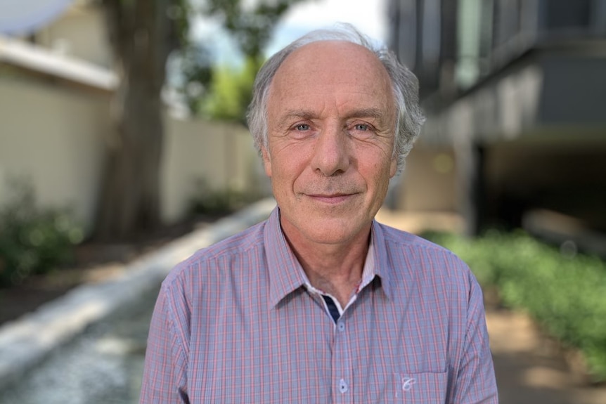 Alan Finkel smiles at the camera wearing a purple shirt