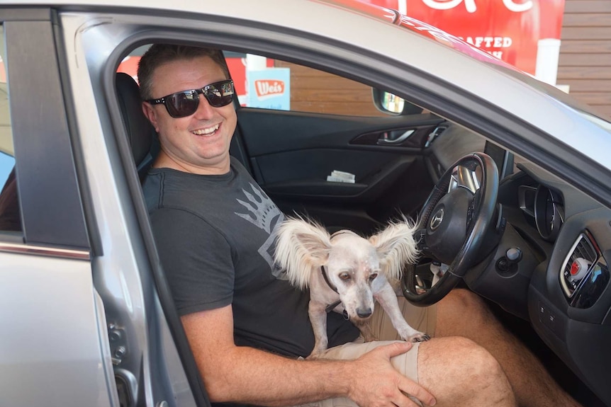 Steve Whitaker sits in his car with his dog at the petrol station.