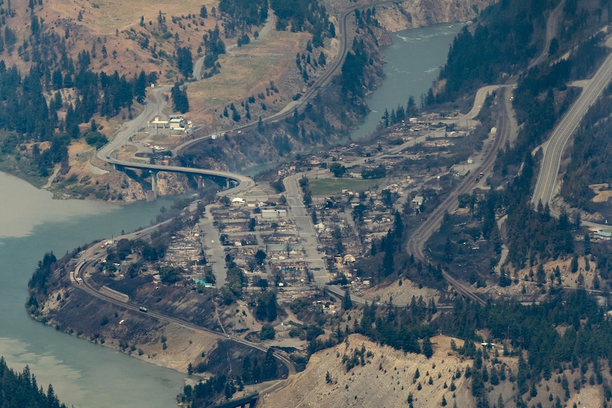 An aerial shot of a small town with many of the buildings destroyed by fire.