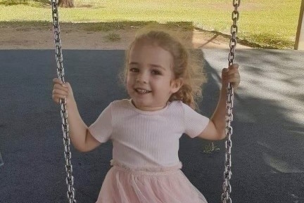 Navaeh Austin on a swing, wearing a pink dress.