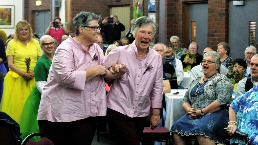 Sally Marks (left) and Trish Bock walk down the aisle at their wedding.