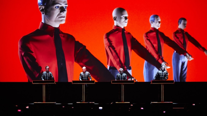 Krafwerk's four members perform on stage with a screen projecting four model dummy versions of them