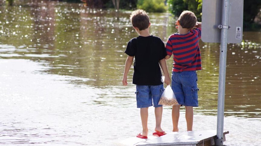 Two boys watch the floodwaters at Boyland Street