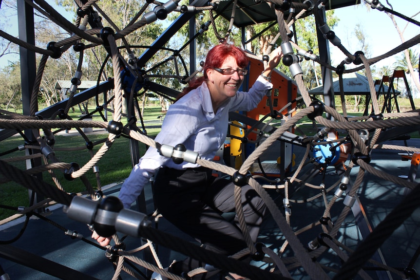 A woman plays on playground equipment