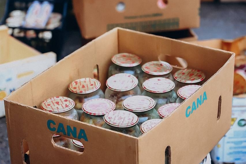 a cardboard box full of glass jars