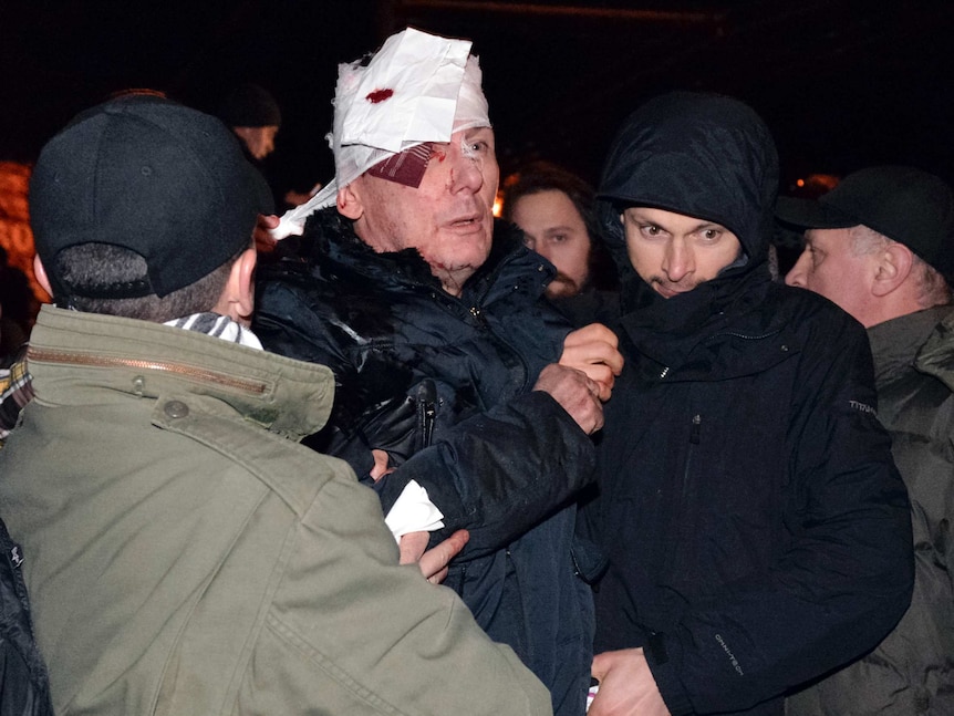 Ukraine's opposition leader Yuriy Lutsenko receives medical help after clashes with riot police near a court in Kiev.