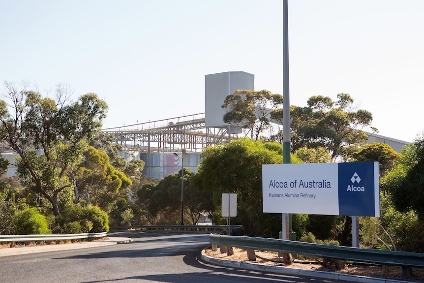 A sign outside Alcoa's Kwinana alumina refinery next to a road leading into the industrial buildings