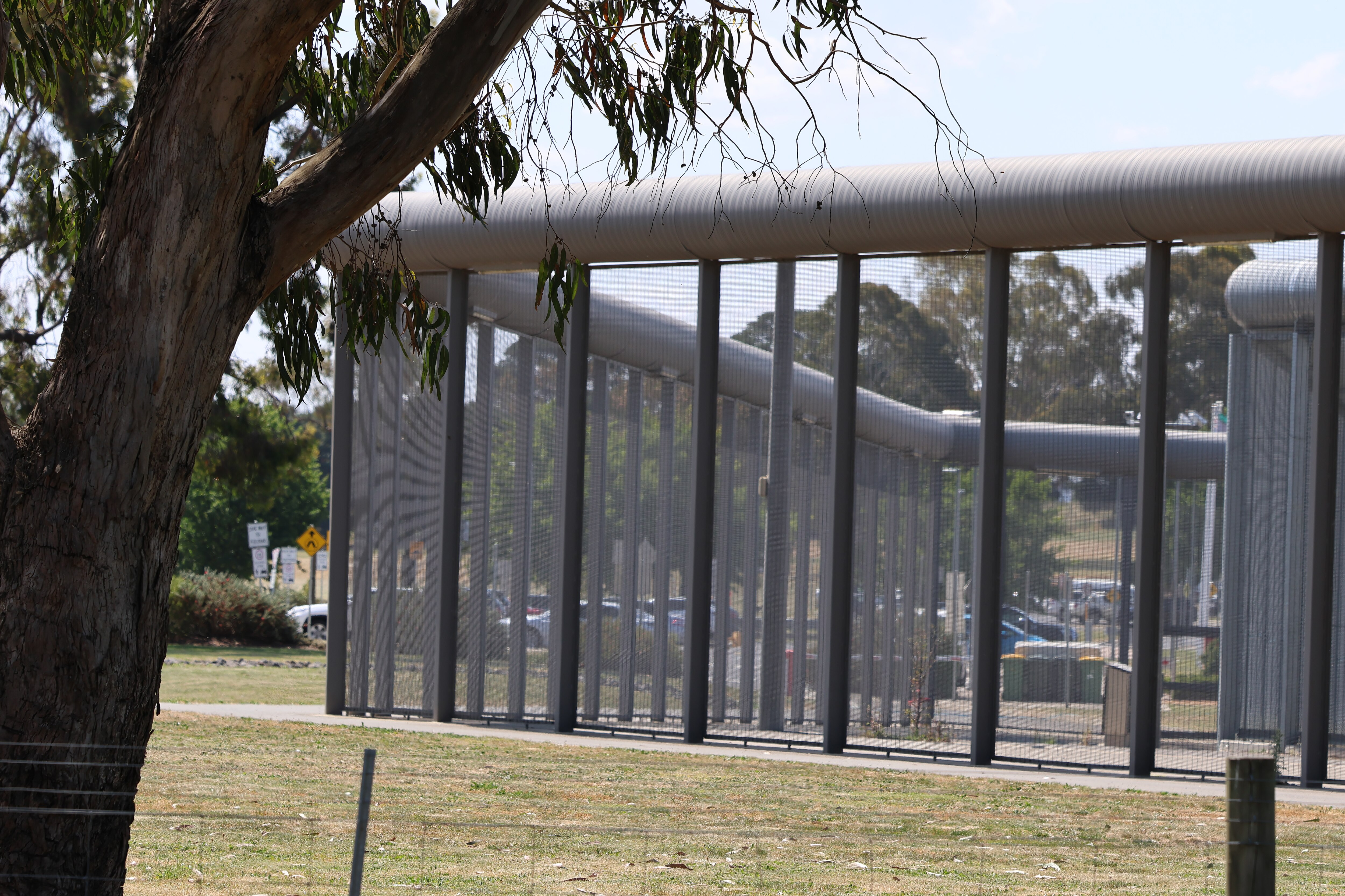 High security fence with tree in foreground