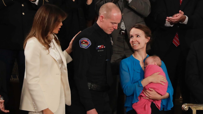 Melania Trump lays a hand on the shoulder of Ryan Holets, who looks at wife Rebecca and baby Hope.