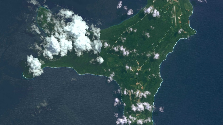 View from the air above Christmas Island, showing clouds, complete green coverage and detention centre