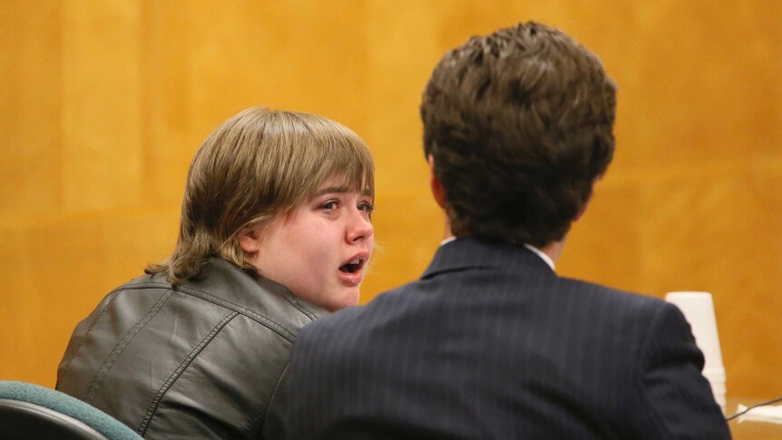 Morgan Geyser looks to her attorney in a courtroom.