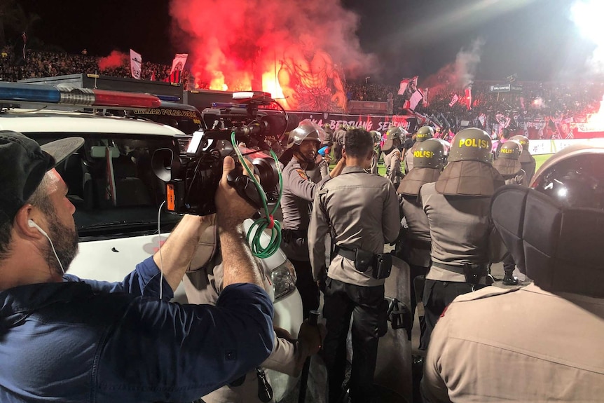 Cameraman Phil Hemingway films a riot at a soccer match.