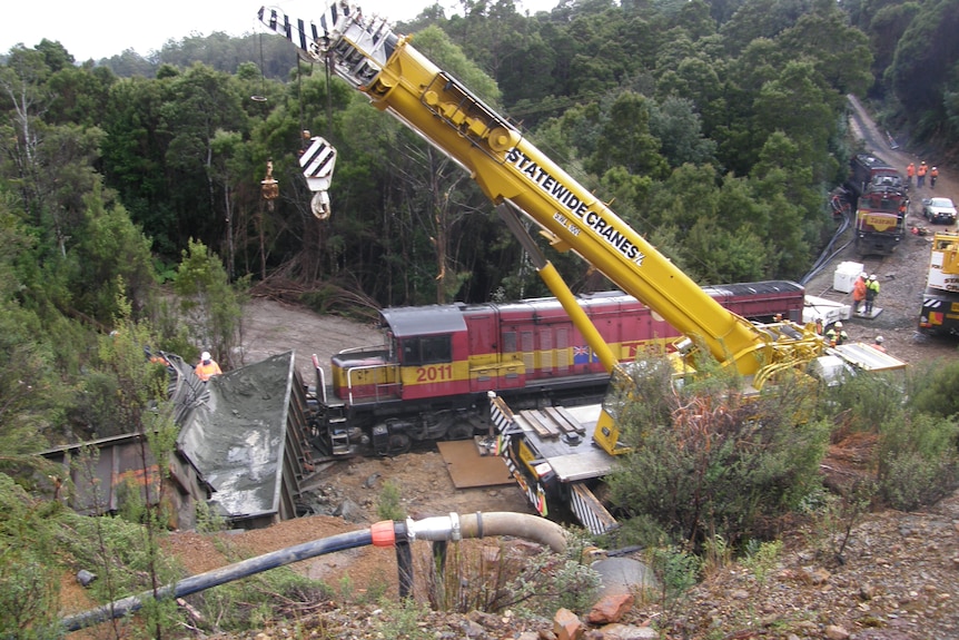 A crane lifts some debris from the site of a train crash.