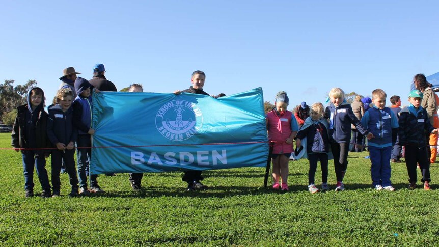 Children hold a banner for their sports house at the School of the Air athletics carnival.