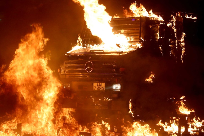 A look at a black police riot vehicle close-up with it being completely engulfed in flames.