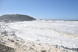 Sea foam and waves wash ashore Coffs Harbour beach 
