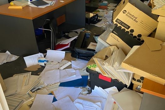 A trashed office building, paper and boxes everywhere