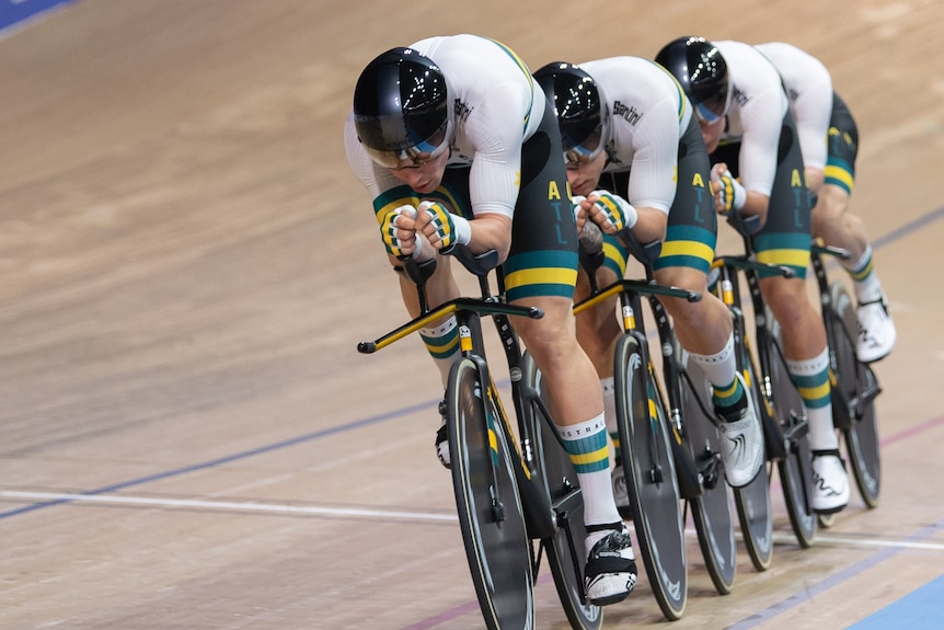 Four men wearing white lycra riding bikes in a row