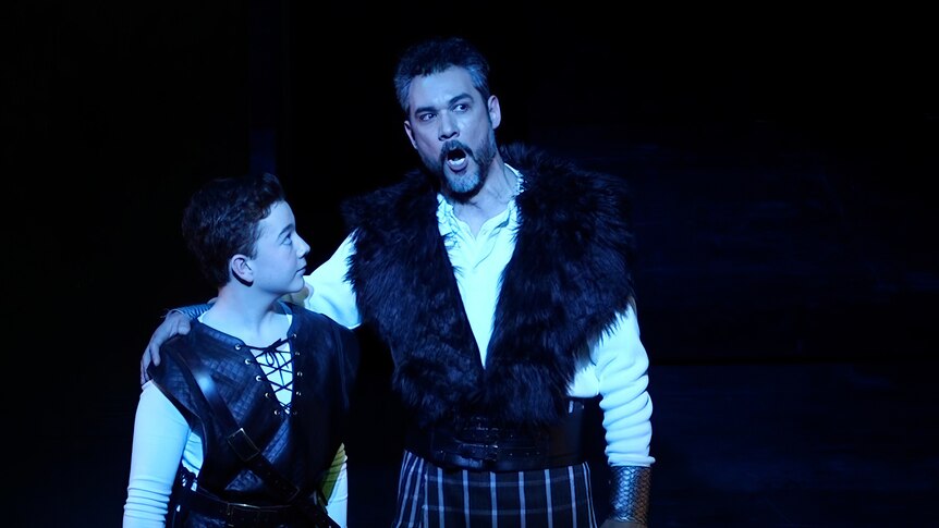 A scene from the opera shows Elliot on stage with another opera singer in mid-song.