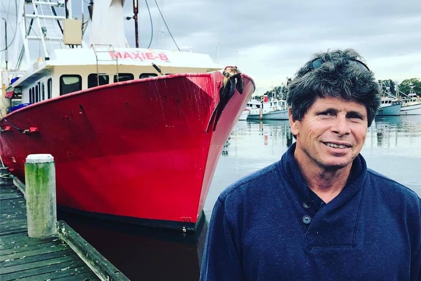 Newcastle fisherman Brett Bollinger standing in front of his fishing trawler