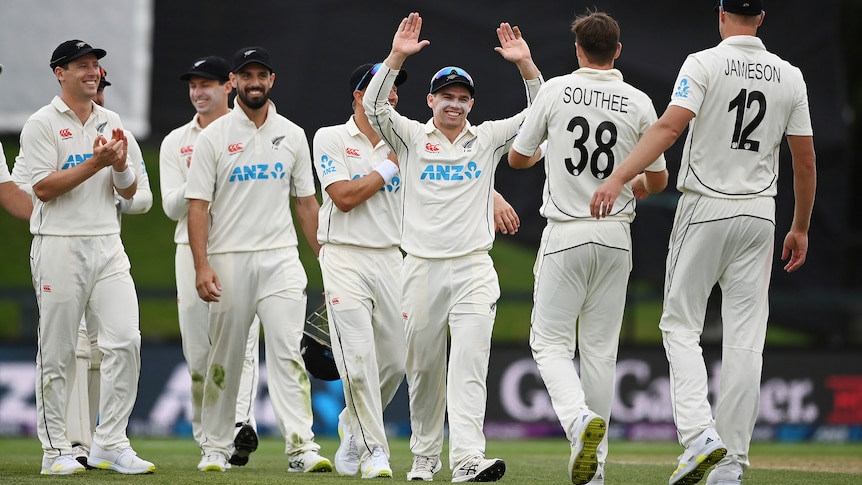New Zealand captain Tom Latham celebrates with his team raising his arms as Tim Southee approaches