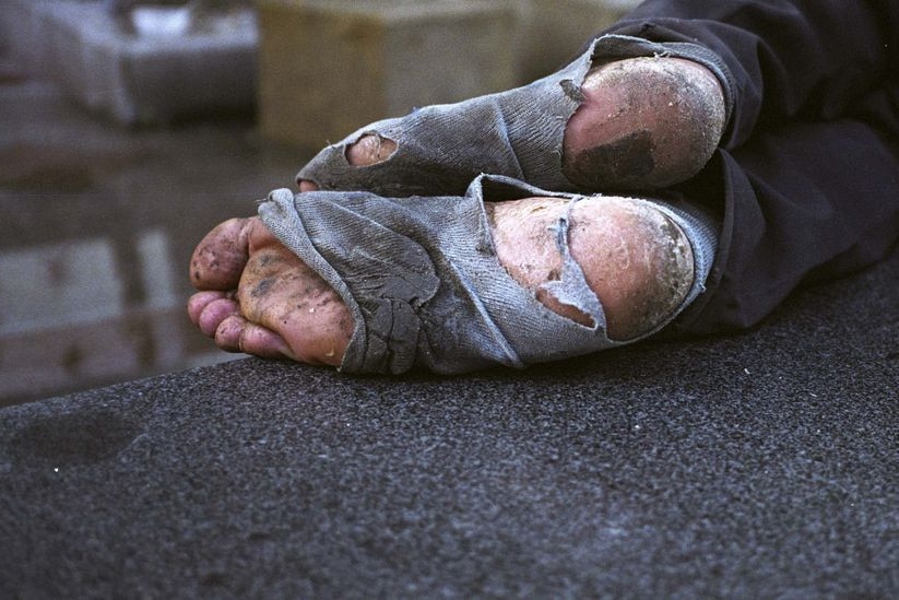 A homeless man naps on a street (Reuters)