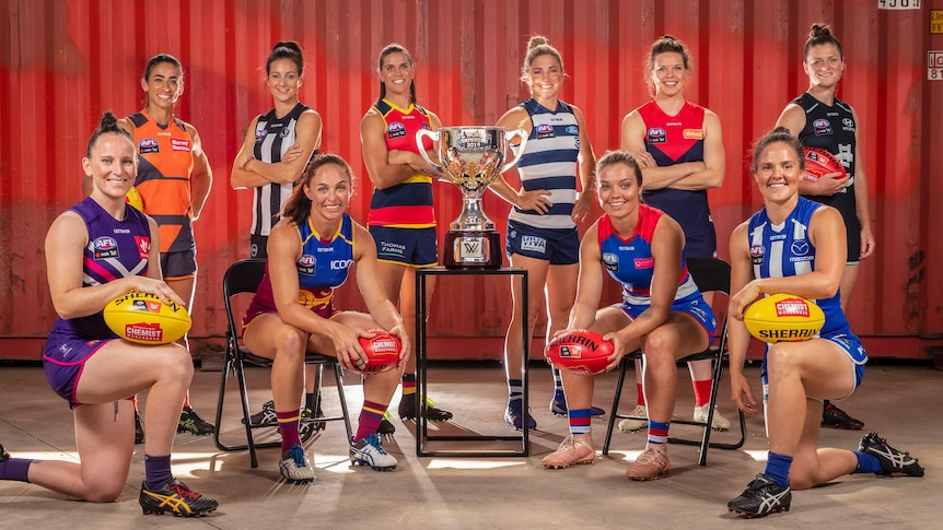 A posed shot of the captains, in uniform, standing around the cup.