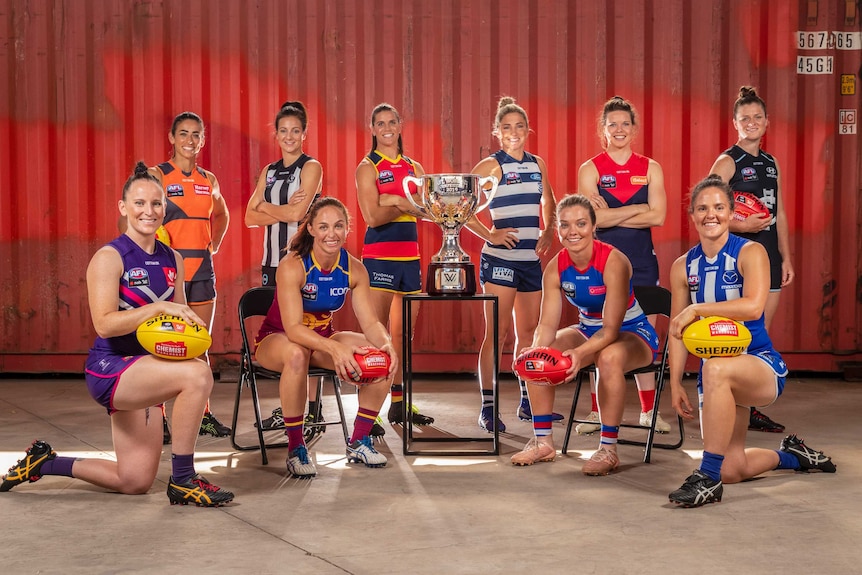 A posed shot of the captains, in uniform, standing around the cup.