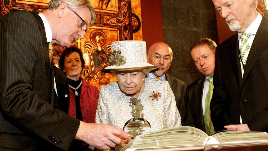 Queen Elizabeth II is shown the Book of Kells in the library at Trinity College