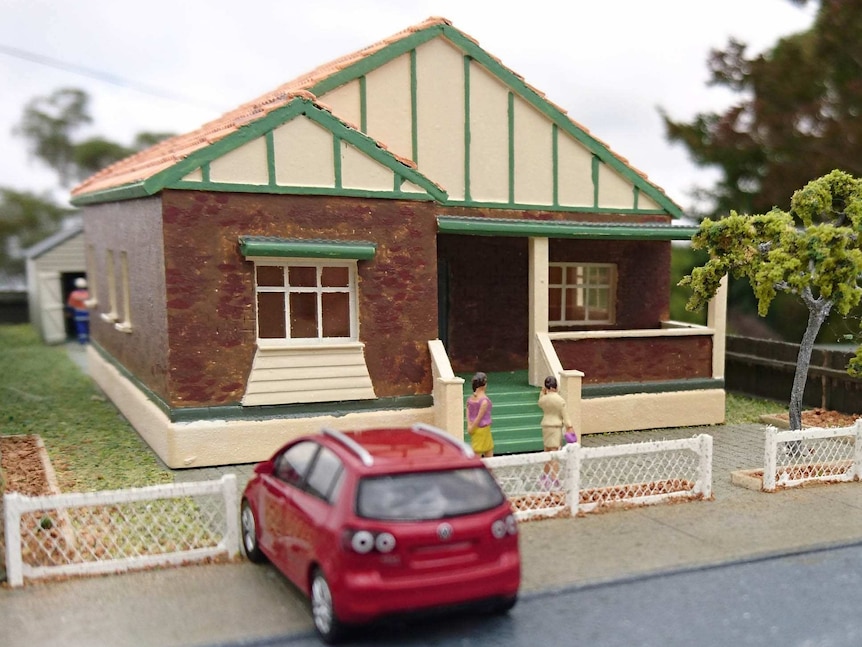 A model of a brick home with a front veranda.