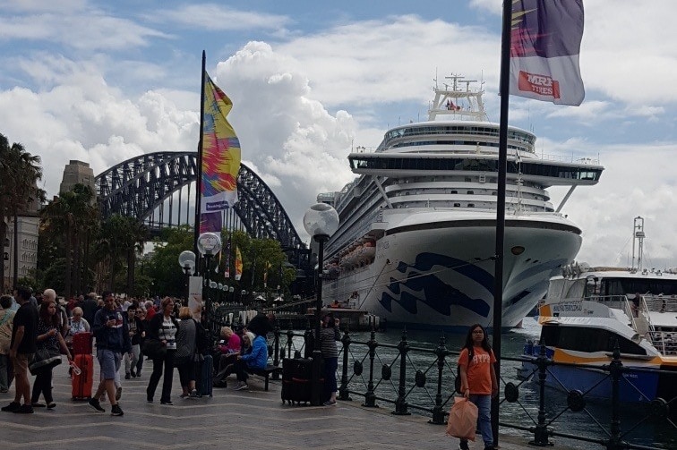 A cruise ship with passengers at a dockside