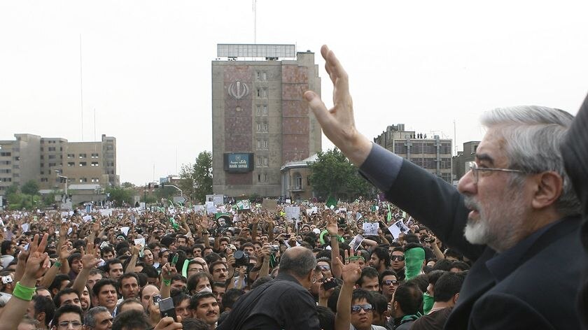 Defeated Iranian presidential candidate Mir Hossein Mousavi waves to protesters during a rally in Te