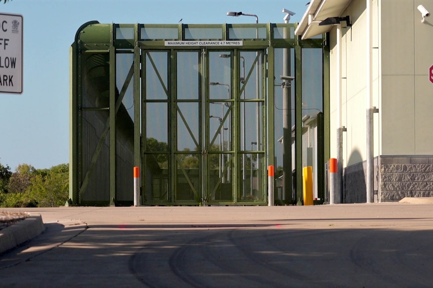 A high green steel mesh fence and gate around the outside of Cleveland Youth Detention Centre