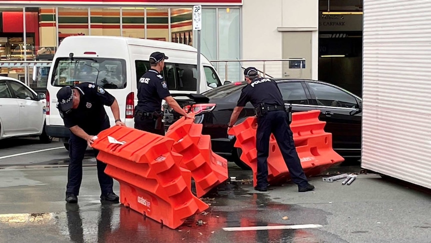 Police officers remove barricades from the Queensland New South Wales border.