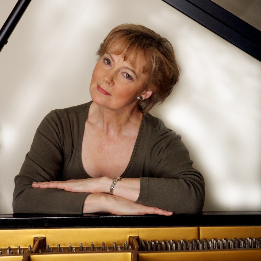 Australian pianist and composer Penelope Thwaites arms folded at the piano.