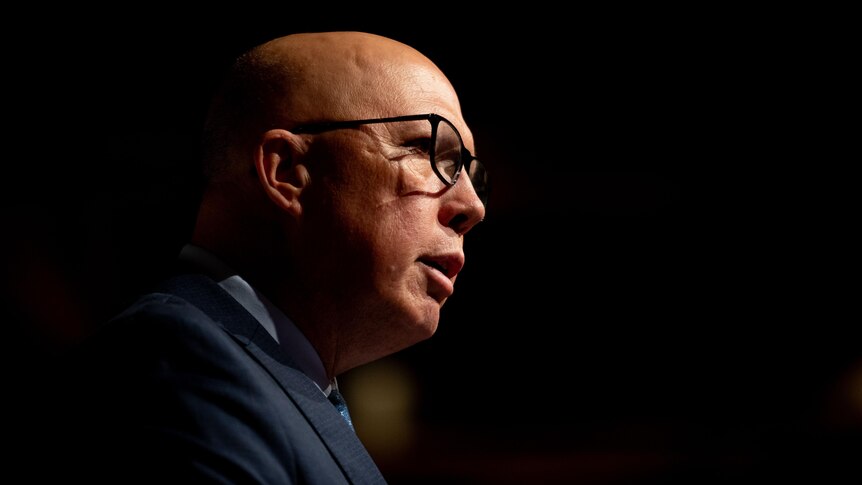 Side profile of bald man wearing glasses speaking. 