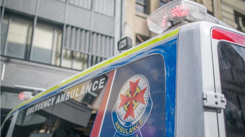 Close up of an ambulance in front of tall buildings