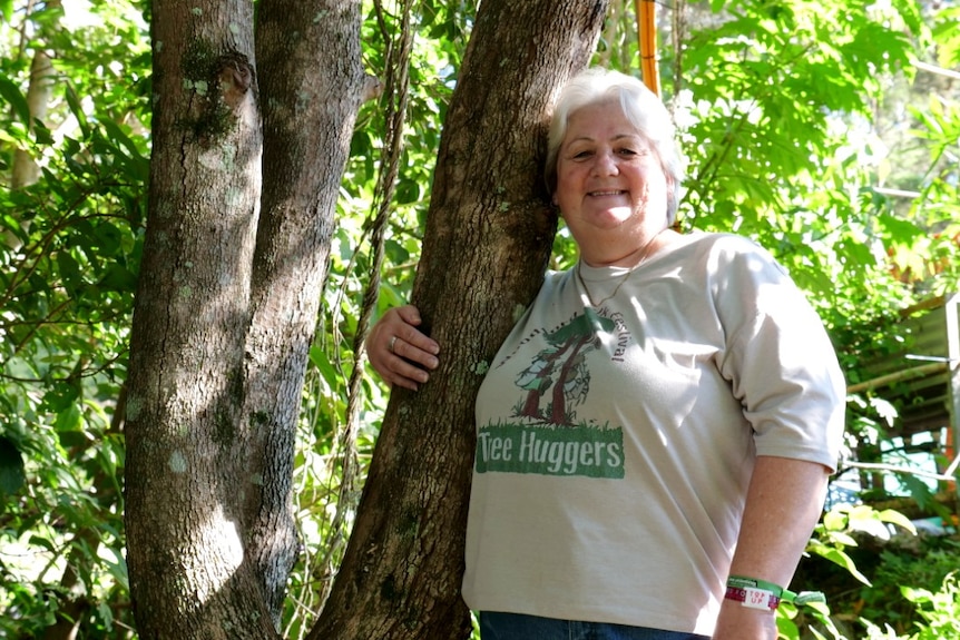 A woman hugs a tree