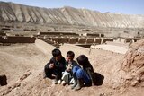Children from the ethnic Hazara minority play in front of their cave home in Afghanistan