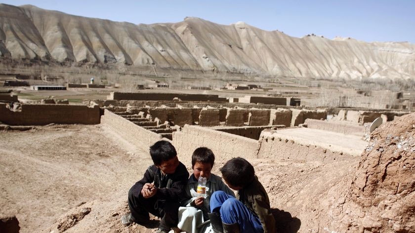 Children from the ethnic Hazara minority play in front of their cave home in Afghanistan