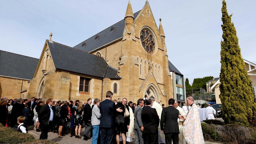 Mourners stand outside St Mary's Cathedral after the state funeral of former senator Brian Harradine.