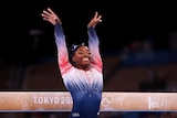 Woman smiling after nailing her balance beam routine at the Olympics