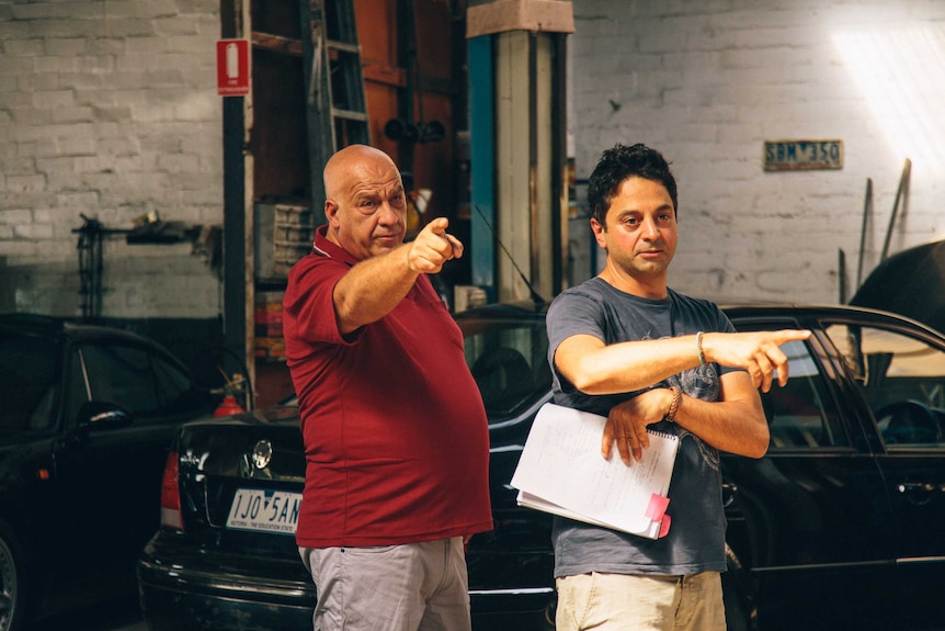 A male director working with a male actor on a film set.