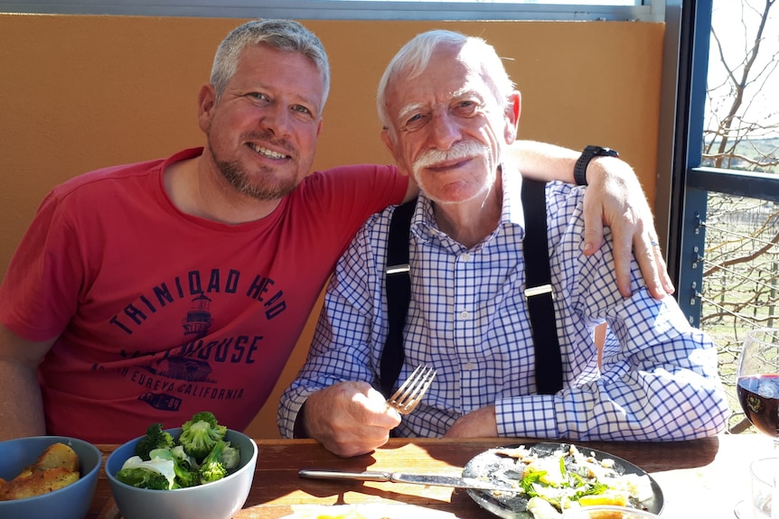 Two men eating food. 