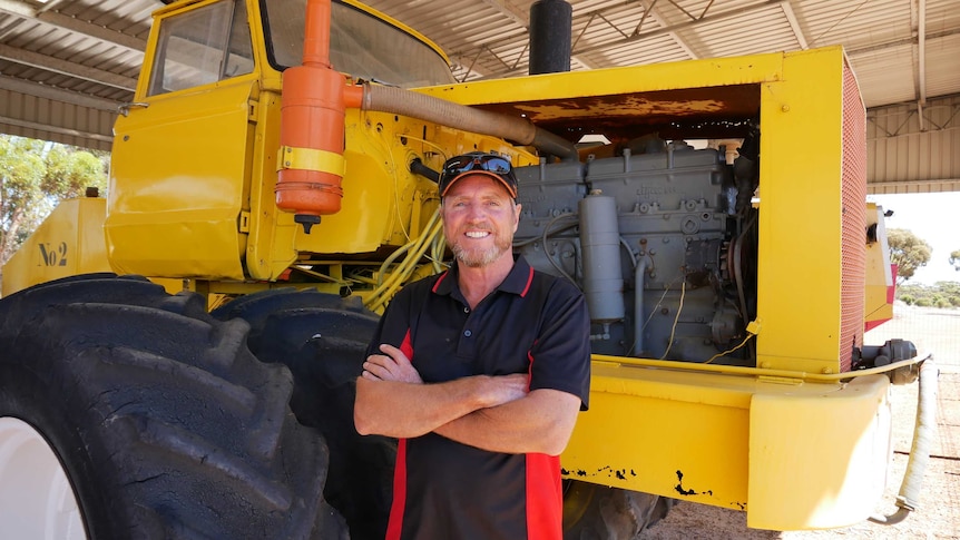 Farmer Colin Penny standing in front of a modified tractor