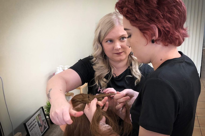 Vanessa Watt shows her apprentice how to practice styling on a hair model