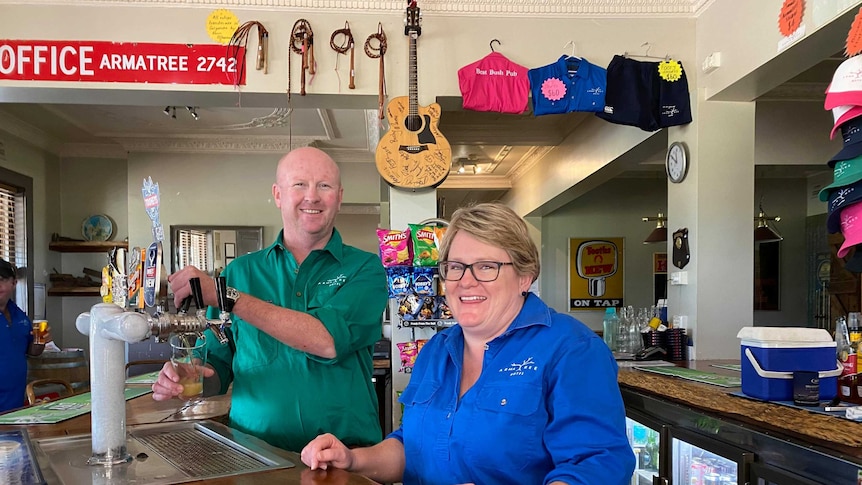 Two people serving beer in a country pub.