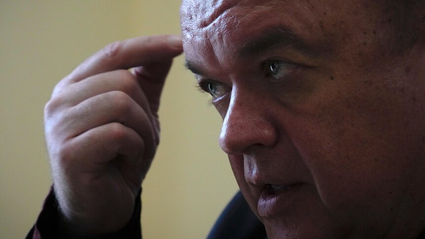 A close-up of Energoatom President Petro Kotin with his thumb and pointer finger rubbing his forehead.