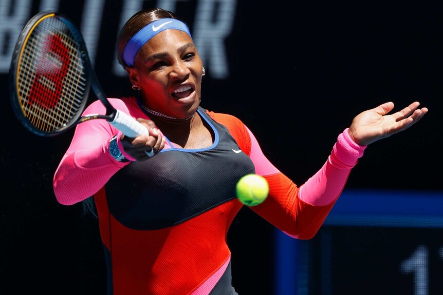 Serena Williams wearing a headband and multicoloured shit plays a forehand at Melbourne Park during the Australian Open