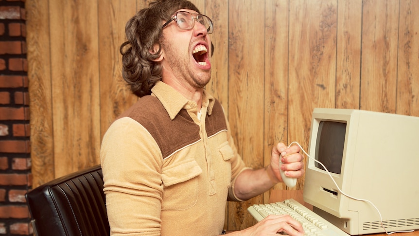A retro looking angry office worker holding mouse and yelling in frustration in comical way
